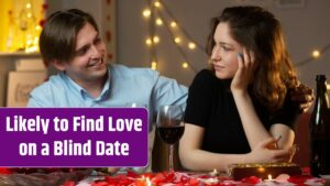 Smiling handsome man holding glass of wine and looking at pleased pretty woman sitting at table in living room on valentine's day.