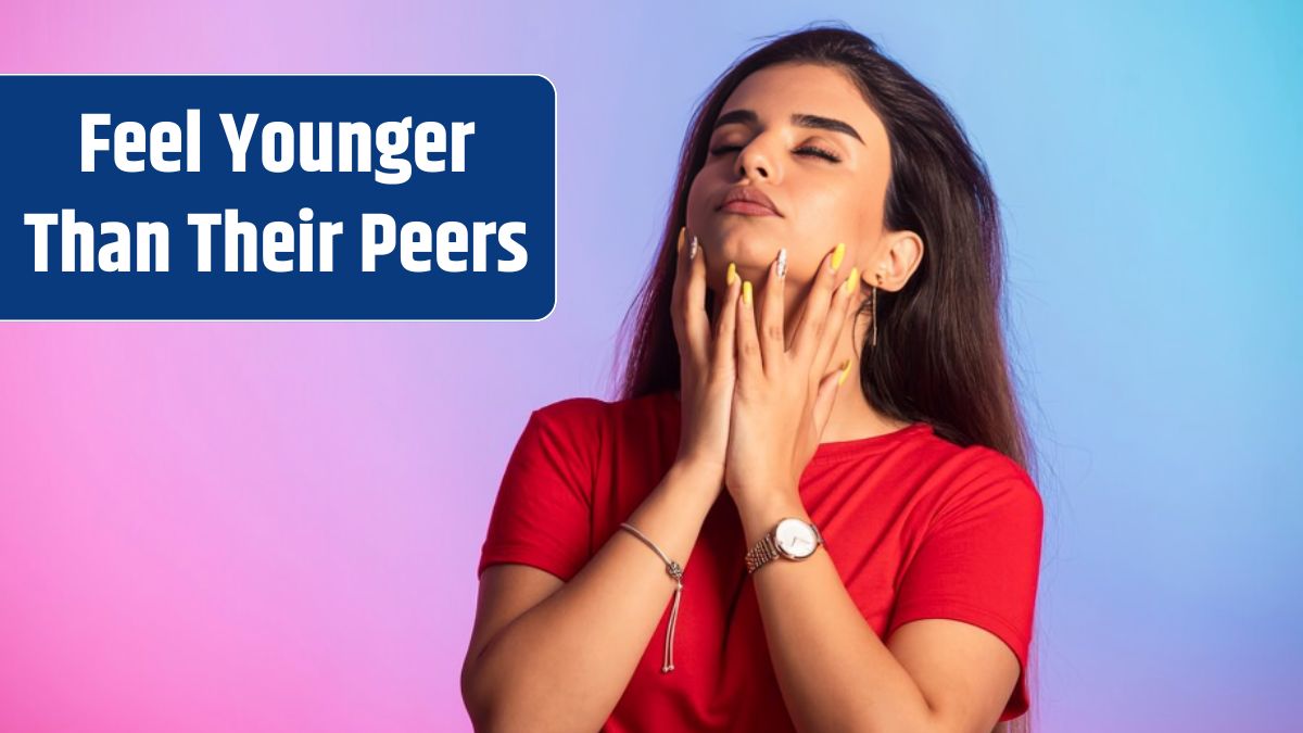 Young girl in red shirt touching her face.